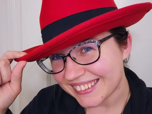 Emilie Nouveau head shot of her wearing a red fedora