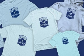 An assortment of 2022 camp shirts. Light blue with navy blue logo. Short sleeved, long sleeved, hoodie, youth size, etc.
